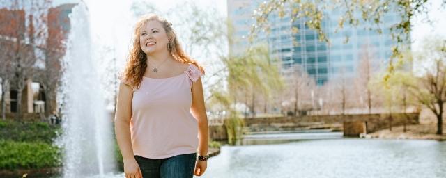 A woman walks by a fountain outdoors