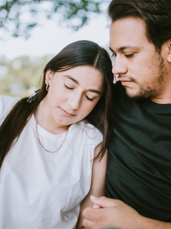 A man and woman sit on a park bench