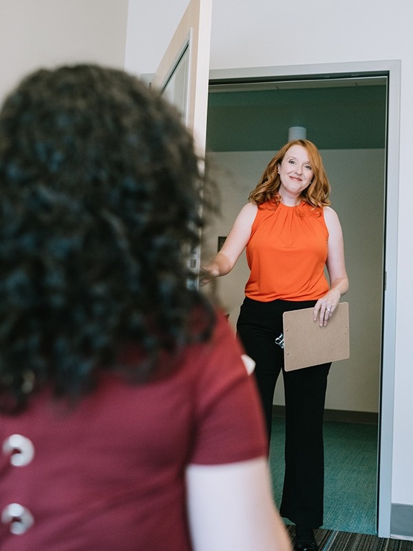 A clinician entering a room to speak with a patient