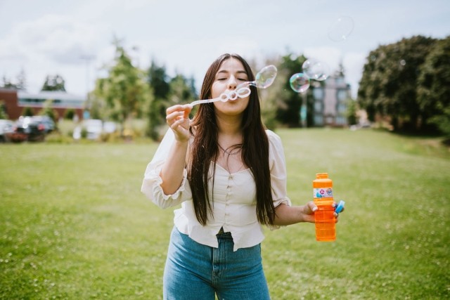 Girl at a park blowing bubbles