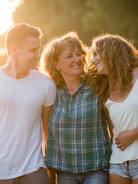 A family standing outdoors at sunset